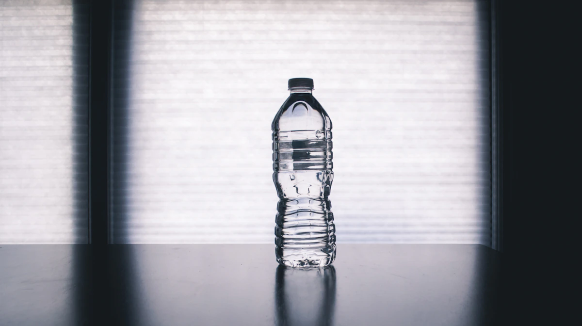 Botella de agua sobre una mesa para acompañar la jornada