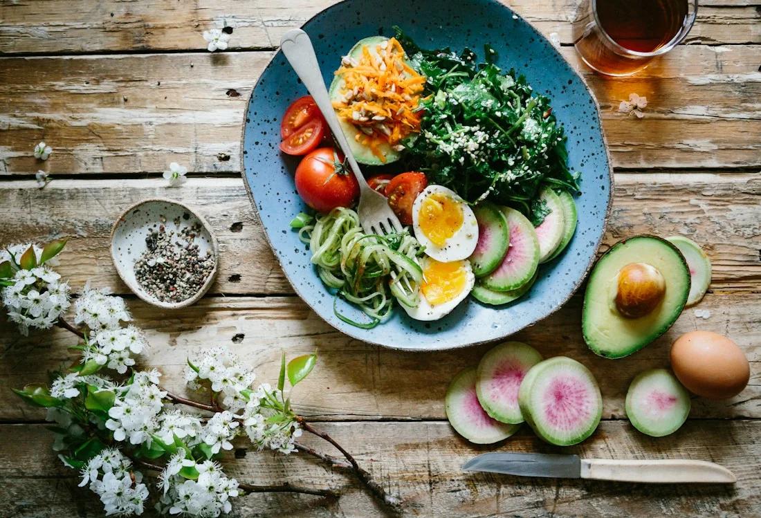 Plato con huevo, verduras y cereales sobre una mesa